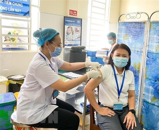 A woman working on front line of COVID-19 fight gets vaccine injection (Photo: VNA)