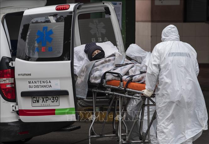 Nhân viên y tế chuyển bệnh nhân Covid-19 tới bệnh viện tại Santiago, Chile. Ảnh: AFP/TTXVN