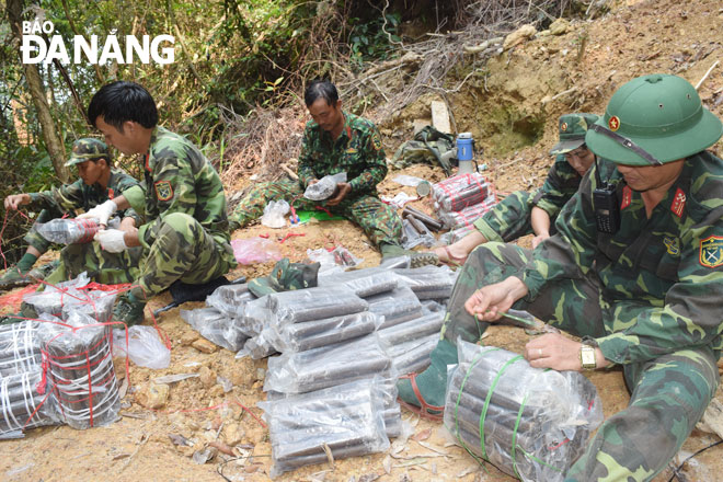Các cán bộ, chiến sĩ Bộ Chỉ huy Quân sự thành phố chuẩn bị thuốc nổ để lắp đặt, đánh sập 3 hầm vàng trái phép tại Tiểu khu 39 thuộc khu vực rừng Cà Nhông vào ngày 20-3-2021. Ảnh: HOÀNG HIỆP