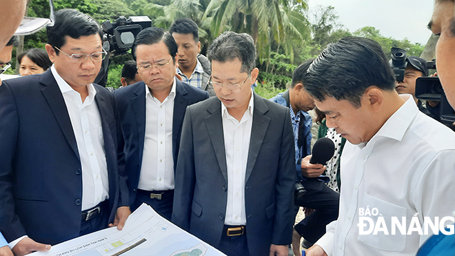 Secretary Quang (3rd left) listening to reports released by the Lien Chieu District authorities about the Nam O community-based eco-tourism site and the north-west traffic axis No 1 projects