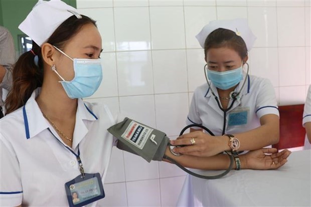 A medical worker receives health checkup before getting COVID-19 vaccine shot. (Photo: VNA)