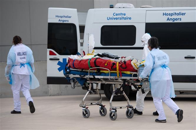Nhân viên y tế chuyển bệnh nhân Covid-19 lên xe cứu thương tại Angers, Pháp ngày 15-3-2021. Ảnh: AFP/TTXVN