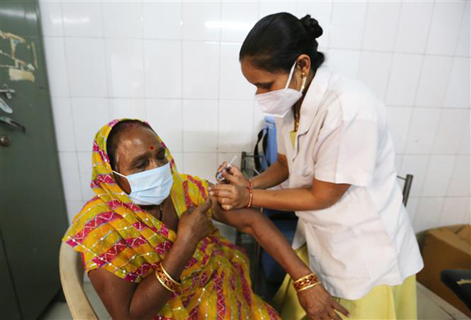  Nhân viên y tế tiêm chủng vaccine ngừa Covid-19 cho người dân tại Bhopal, Ấn Độ, ngày 25-3-2021. Ảnh: THX/TTXVN