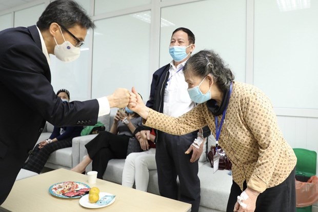 Deputy Prime Minister Vu Duc Dam visits volunteers participating in the second trial phase of Nano Covax. (Photo: VNA)