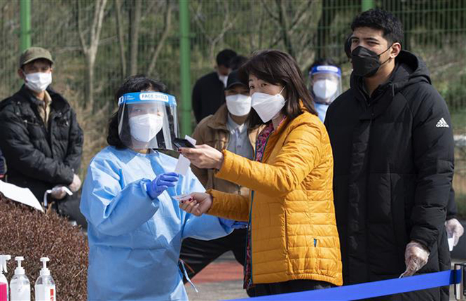 Hướng dẫn người dân tại một điểm xét nghiệm Covid-19 ở Hwaseong, tỉnh Gyeonggi, Hàn Quốc, ngày 14-3-2021. Ảnh: THX/TTXVN