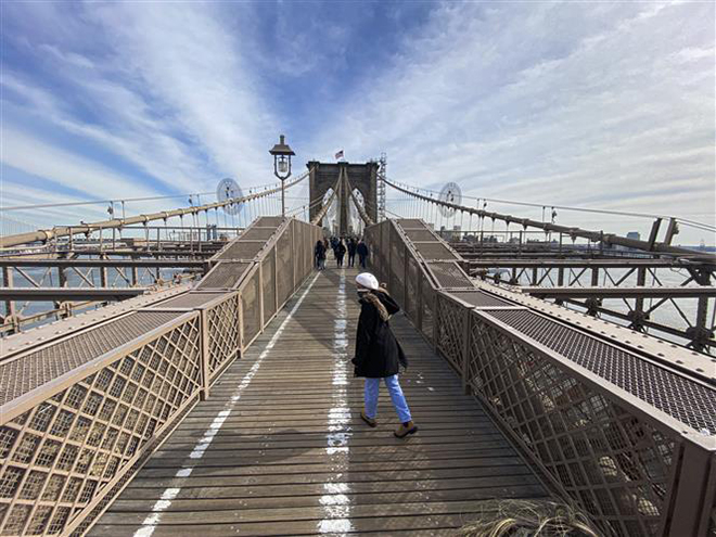  Du khách tham quan Cầu Brooklyn ở thành phố New York, Mỹ, ngày 26-2-2021. Ảnh: AFP/ TTXVN