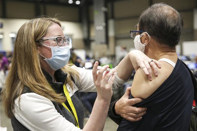 Nhân viên y tế tiêm vaccine ngừa COVID-19 cho người dân tại Seattle, Washington, Mỹ, ngày 13/3/2021. Ảnh: AFP/ TTXVN