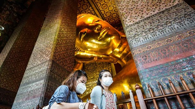 Visitors pass the Reclining Buddha at the temple Wat Pho in Bangkok. (Photo: asia.nikkei.com)