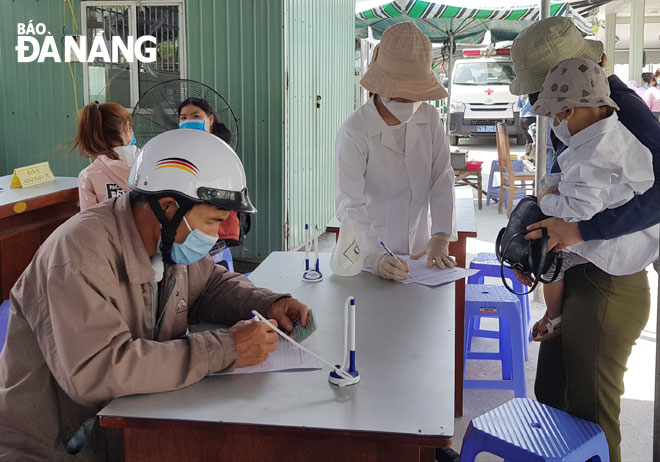 Người dân khai báo y tế khi đến khám, điều trị tại Trung tâm Y tế quận Sơn Trà. Ảnh: PHAN CHUNG