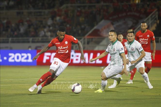 Pha tranh bóng giữa các cầu thủ giữa đội chủ nhà TP Hồ Chí Minh (áo đỏ) và đội Bình Định (áo trắng). Ảnh: Thanh Vũ/TTXVN
