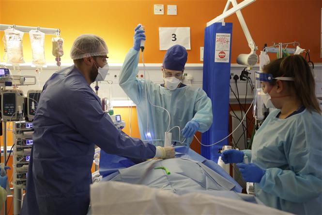 Nhân viên y tế điều trị cho bệnh nhân COVID-19 tại bệnh viện ở London, Anh. Ảnh: AFP/ TTXVN