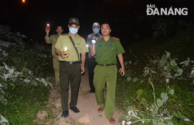 Lực lượng chức năng đi bộ băng rừng đến nhiều địa điểm ở bán đảo Sơn Trà để tuyên truyền, vận động giải tán các nhóm người dã ngoại, cắm trại, sử dụng lửa để chế biến thức ăn. Ảnh: HOÀNG HIỆP