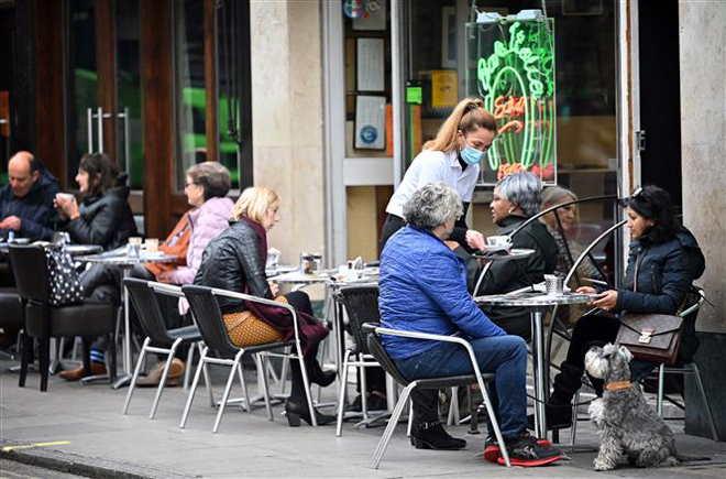 Một quán cà phê mở cửa phục vụ khách hàng tại London, Anh ngày 18-10-2020. Ảnh: AFP/TTXVN