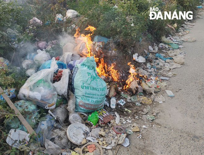 Người dân tự ý đốt những đống rác vương vãi tại khu vực nghĩa trang Hòa Sơn. Ảnh: H.L	