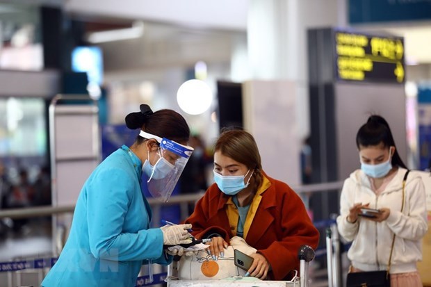 Vietnam Airlines' staff support passengers in the e-health declaration procedure. (Photo: VNA)
