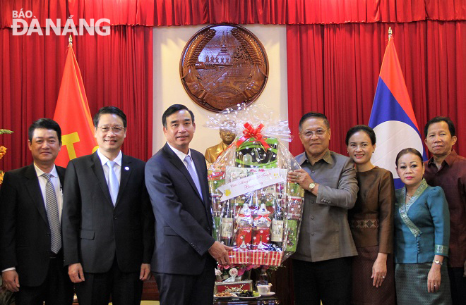 Da Nang Party Committee Deputy Secretary cum municipal People's Committee Chairman Le Trung Chinh (3rd, from left) presenting a gift to the Lao Consulate General in Da Nang on the occasion of Bunpimay Festival 2021