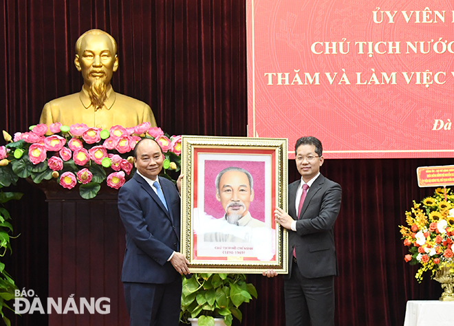 State President Nguyen Xuan Phuc (left) presenting a portrait of late President Ho Chi Minh to Da Nang Party Committee Secretary Nguyen Van Quang