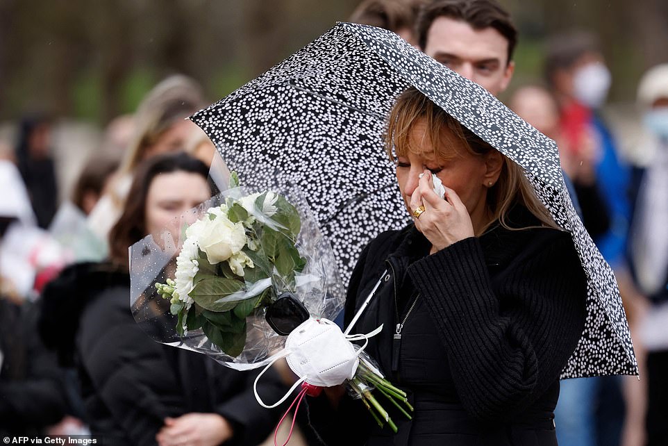 Người phụ nữ cầm hoa tại Cung điện Buckingham xúc động khi chứng kiến nghi thức bắn đại bác. Ảnh: Getty Images