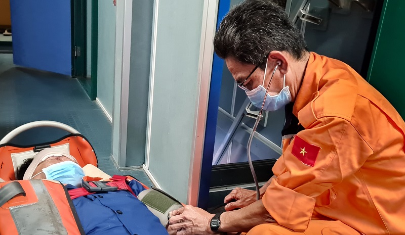 The injured fisherman was given initial first aid before being brought back to the mainland for further treatment (Photo: Nhan Dan Newspaper )