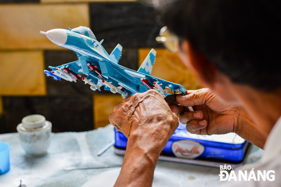 Thanh is seen assembling a model missile on a replica of an aircraft.
