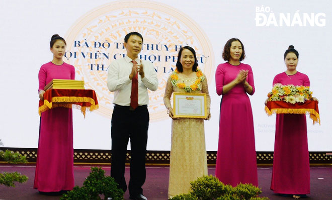 Bà Đỗ Thị Thúy Hà (giữa) nhận khen thưởng của lãnh đạo quận Hải Châu đối với tập thể Chi hội Phụ nữ Thanh Sơn 1A về thành tích xuất sắc trong các phong trào thi đua, các cuộc vận động do Mặt trận và các hội, đoàn thể phát động năm 2019. 			          Ảnh: NGUYỄN XUÂN TƯ