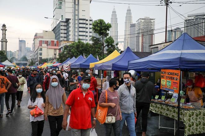  Người dân Malaysia đeo khẩu trang tại một khu chợ. Ảnh: Straits Times