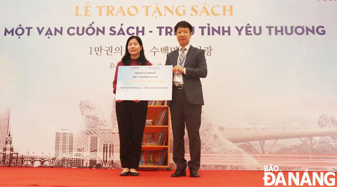 The representative of Hansae Vietnam Co Ltd (right) presented the symbolic board on book donations to the representative of the Da Nang Department of Education and Training.  