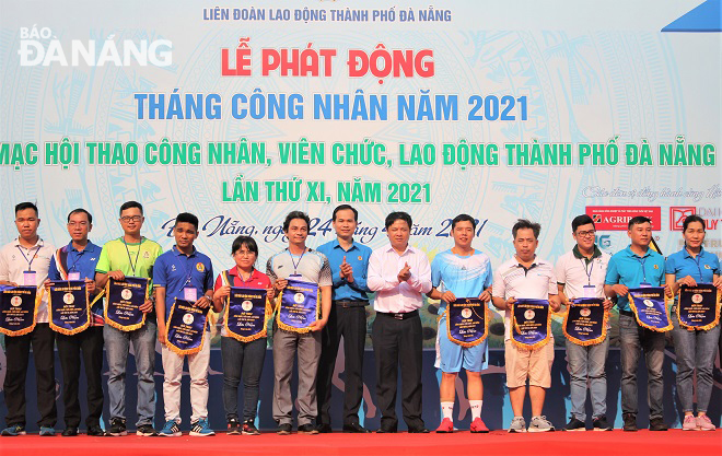 Da Nang People’s Council Chairman Luong Nguyen Minh Triet (6th, right) presenting souvenir flags to the teams participating in  the 11th Sports Festival for White and Blue Collar Workers in Da Nang.
