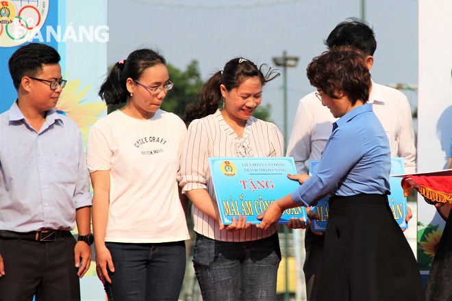 Da Nang Labour Federation Vice Chairwoman Dinh Thi Thanh Ha (right) handing presenting symbolic boards on house donations to poor employees.