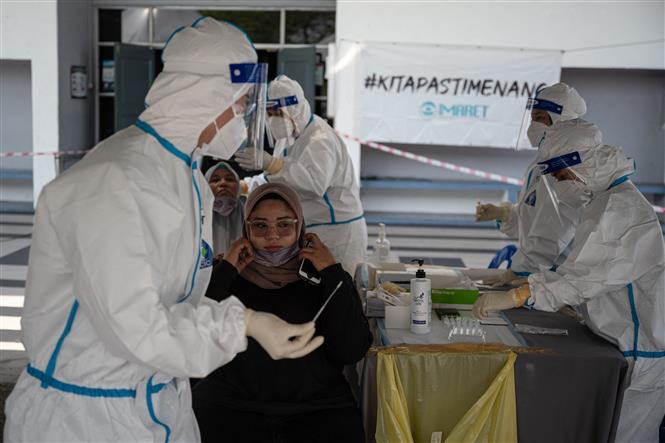 Nhân viên y tế lấy mẫu xét nghiệm Covid-19 tại Kuala Lumpur, Malaysia. Ảnh: AFP/TTXVN