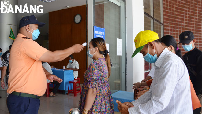 The Museum of Da Nang staff measuring the temperature of visitors before entering the venue. Photo: THU HA