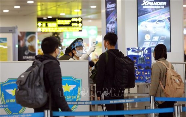 Checking a passenger' body temperature at the Noi Bai international airport (Photo: VNA)