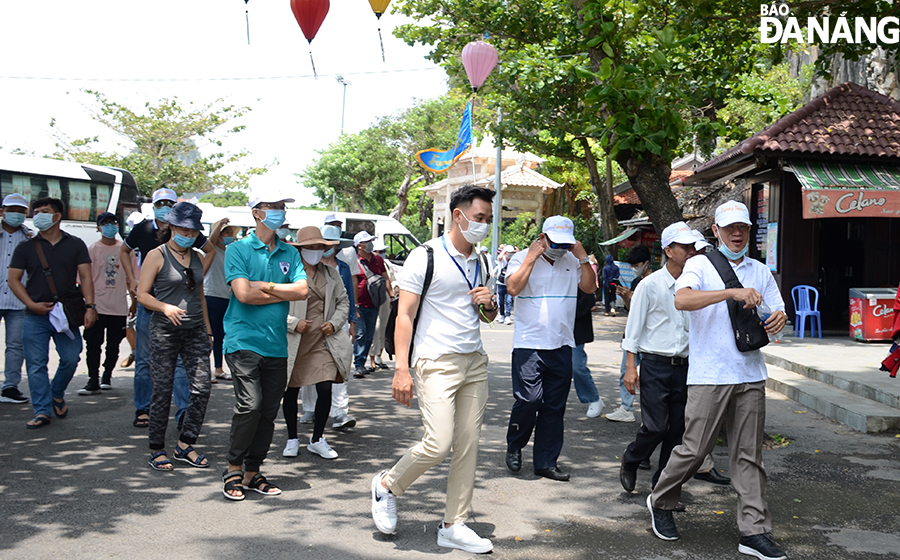 Visitors are seen wearing face masks during their trip to the Marble Mountain Tourist Area on April 30. Photo: THU HA