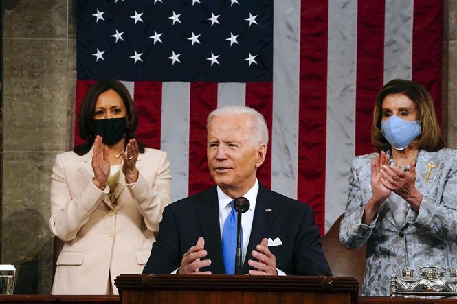 Ngày 28/4/2021, Tổng thống Mỹ Joe Biden (trong ảnh, giữa) có bài phát biểu đầu tiên trước Quốc hội theo lời mời của Chủ tịch Hạ viện Nancy Pelosi. Đây được xem là sự kiện đánh dấu 100 ngày đầu tiên ông Biden lên nắm quyền, trong bối cảnh ông phải đương đầu với những vấn đề cấp thiết, trong đó có đại dịch viêm đường hô hấp cấp COVID-19 và những khó khăn kinh tế mà nước Mỹ đang phải đối mặt. Ảnh: AFP/ TTXVN