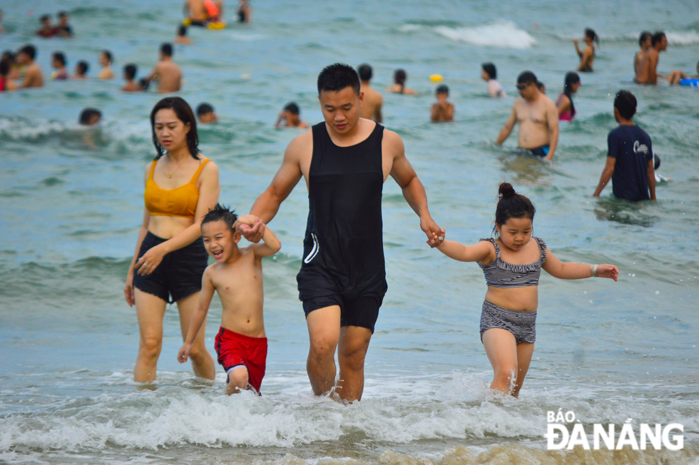 Tourists enjoy fun, relaxing moments whilst swimming in crystal blue water.