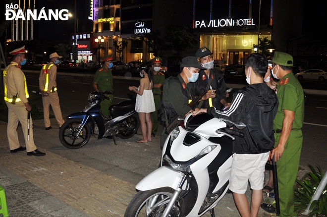 Traffic police officers pull over motorbike drivers for administrative inspection on Vo Van Kiet Street