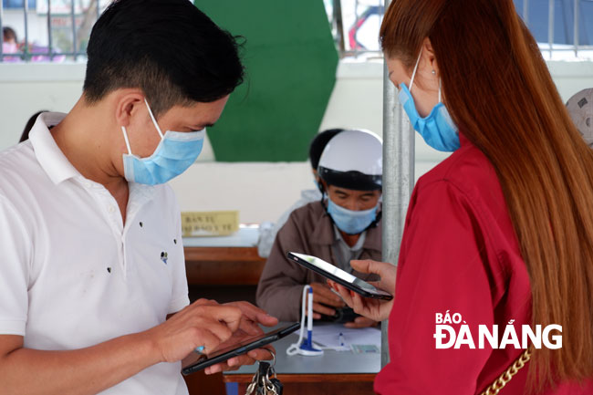 Người dân thực hiện khai báo y tế online khi đến khám, điều trị tại Trung tâm Y tế quận Sơn Trà. Ảnh: PHAN CHUNG