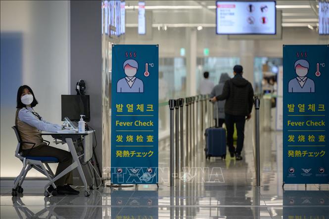 Đo thân nhiệt phòng lây nhiễm Covid-19 tại sân bay quốc tế Incheon, Hàn Quốc. Ảnh: AFP/TTXVN
