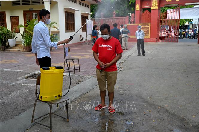 Khử khuẩn phòng lây nhiễm Covid-19 tại Phnom Penh, Campuchia, ngày 30-4-2021. Ảnh: AFP/TTXVN