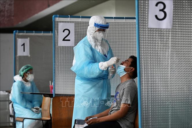 Nhân viên y tế lấy mẫu xét nghiệm Covid-19 tại Bangkok, Thái Lan. Ảnh: AFP/TTXVN