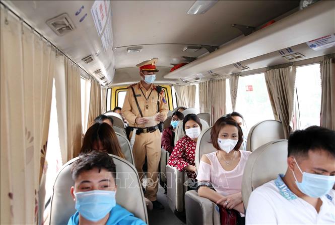 Lực lượng CSGT số 8 Công an TP Hà Nội kiểm tra và nhắc nhở người dân đi xe khách đeo khẩu trang trên xe, ngày 2-5-2021. Ảnh: Phạm Kiên/TTXVN