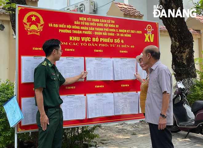 Cán bộ Biên phòng cửa khẩu cảng Đà Nẵng (trái) tuyên truyền cho người dân về công tác bầu cử tại phường Thuận Phước, quận Hải Châu. Ảnh: HỒNG QUANG