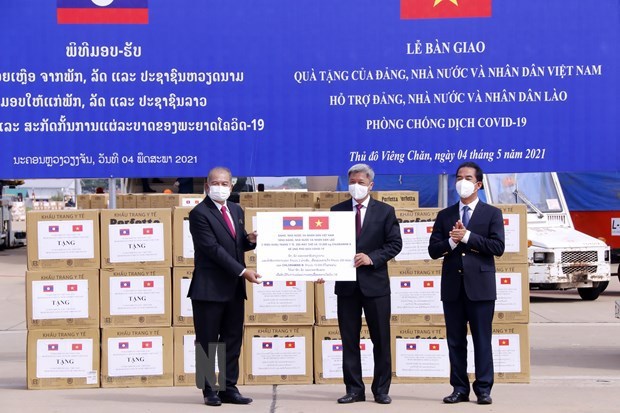Vietnamese Deputy Minister of Health Nguyen Truong Son (centre) symbolically presents the assistance from the Party, State, and people of Vietnam to Laos at the ceremony at Wattay International Airport on May 4 (Photo: VNA)
