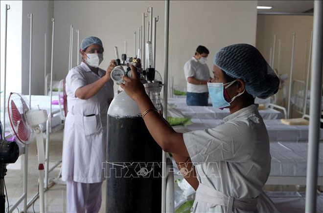 Nhân viên y tế chuẩn bị bình oxy cho bệnh nhân Covid-19 tại Kolkata, Ấn Độ ngày 3-5-2021. Ảnh: THX/TTXVN