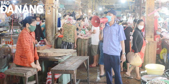 COVID-19 prevention task forces in in Tho Quang Ward, Son Tra District reminds shoppers and traders at the Mai Market to abide by the mandatory regulations on COVID-19 prevention and control. (Photo taken on May 4 by PHAN CHUNG)