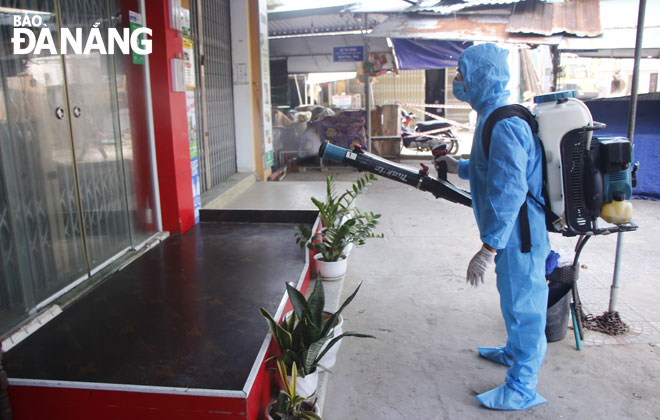 Nhân viên y tế quận Sơn Trà phun hóa chất khử khuẩn khu vực chợ Phước Mỹ.       Ảnh: XUÂN DŨNG