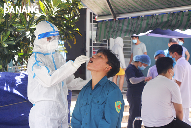 A medical worker collecting a throat and nose swab from a resident living at the 