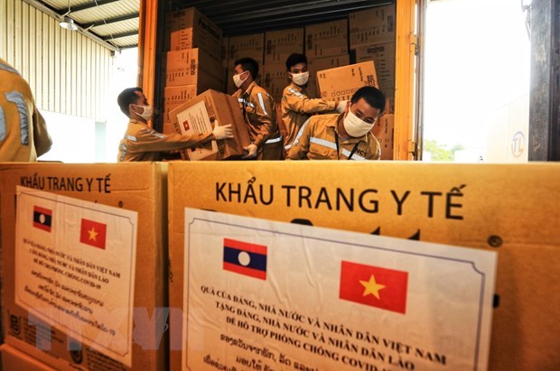 Airport staff load aid packages from Vietnam to an aircraft flying to Laos to help the country battle COVID-19 (Photo: VNA)