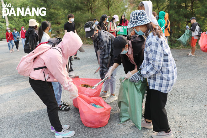 Các tình nguyện viên thu gom rác tại chương trình “Clean up Son Tra 2021 - Vì một Sơn Trà xanh” do Ban Quản lý bán đảo Sơn Trà và các bãi biển du lịch Đà Nẵng tổ chức vào tháng 3-2021. Ảnh: VĂN HOÀNG