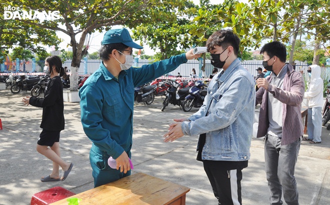 Functional forces measure the body temperature of a man before sample taking. Photo: L.HUNG